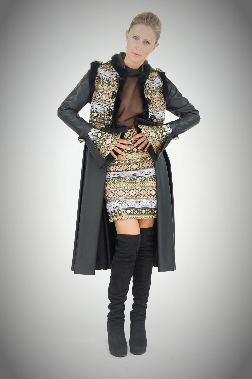 Modelo posando con un traje de la colección con piezas bordadas en oro.